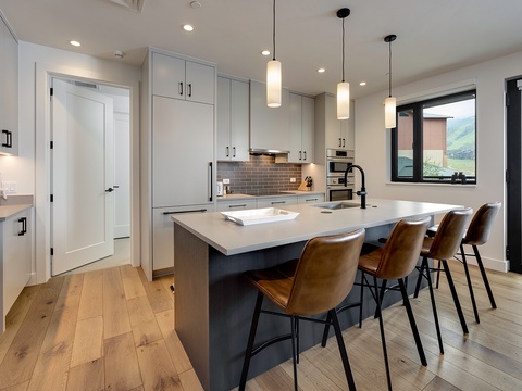 Gather around the spacious island in this modern kitchen where sleek cabinetry meets stunning mountain views. The open design and natural light create the perfect backdrop for your stay.