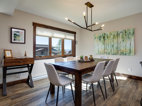 Gather around this inviting dining table where shared meals become treasured memories. The modern chandelier and natural light create a warm ambiance perfect for your morning coffee or evening dinners.