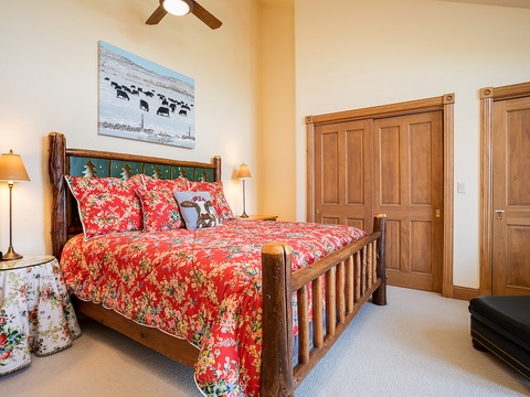 Step into your cozy retreat where a handcrafted wooden bed draped in vibrant floral linens promises restful nights, while warm lighting and rustic touches create a welcoming, home-away-from-home atmosphere.
