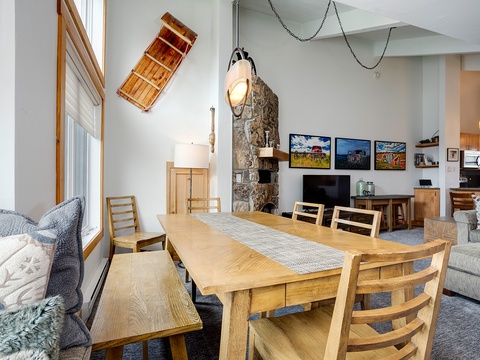 Gather around this beautiful rustic dining table where meals become memories. The soaring ceilings, stone fireplace, and charming canoe décor create a warm, mountain-lodge feel perfect for your group.