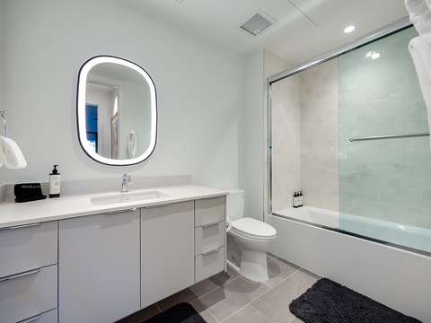 Step into your bright, modern bathroom with a sleek soaking tub and a spacious walk-in shower behind elegant glass. Plush towels and stylish vanity finishes complete your private sanctuary.