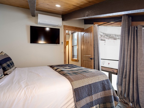 Wake up to breathtaking ski slope views from your cozy room, where rustic wood accents and modern comfort blend seamlessly for your perfect winter retreat.