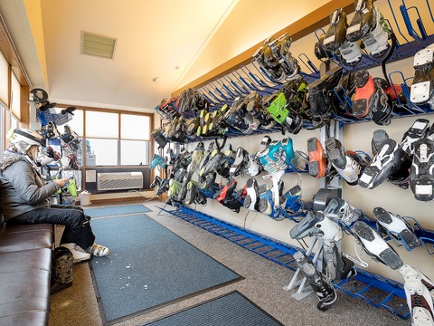 A well-stocked ski and snowboard rental room awaits your adventure on the slopes, with gear for all skill levels neatly organized.