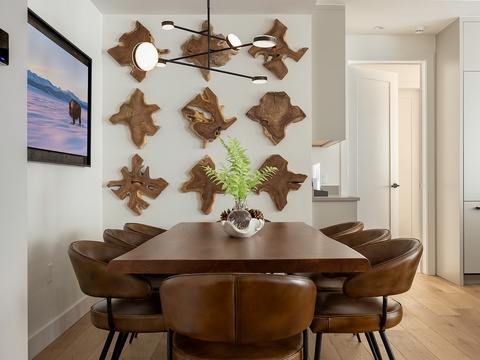 Gather around this warm, inviting dining space with its natural wood accents and artful lighting. You'll find a perfect spot for shared meals and conversation in this stylish retreat.