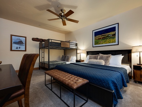 Unwind in your comfortable bedroom featuring a plush bed and convenient bunk beds, perfect for families or groups seeking a restful retreat after days of adventure.