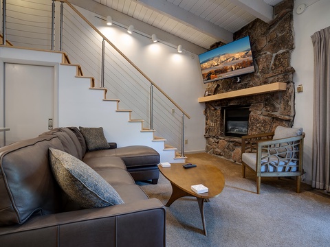 Unwind in your spacious living area with a stunning stone fireplace, vaulted ceilings, and cozy seating where you can relax and make yourself at home.