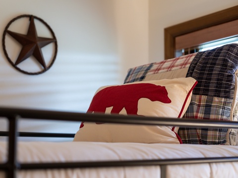 Cozy bunk beds dressed in rustic plaid bedding invite you to settle in after a day of adventure, with warm textures and thoughtful touches making this space feel like home.