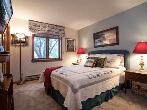 Unwind in your cozy mountain retreat with plush bedding, charming wildlife accents, and tranquil forest views from your window—perfect for restful evenings after adventure-filled days.