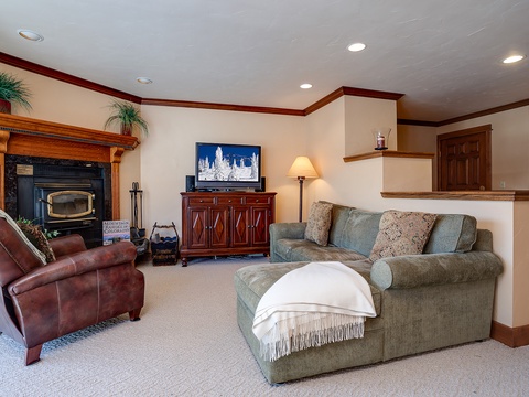 Unwind in your cozy living room with a fireplace, comfortable seating, and entertainment center—perfect for relaxing evenings after your adventures.