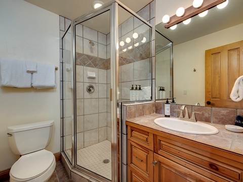Step into your private bathroom, where crisp linens, warm wood tones, and sparkling finishes await. Enjoy a refreshing shower and prepare for your day in this inviting space.