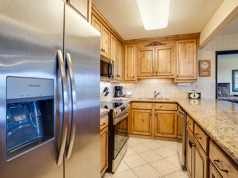 Your fully equipped kitchen features modern stainless steel appliances, elegant granite countertops, and warm wood cabinetry—everything you need to prepare your favorite meals in comfort.