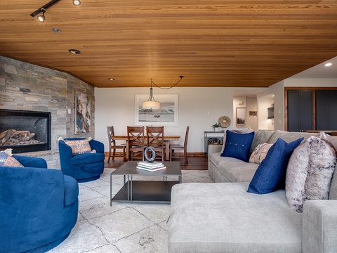 Settle into this inviting living space where rich wood ceilings frame your mountain retreat. Plush seating surrounds the warming fireplace, creating the perfect spot for cozy evenings and memorable conversations.