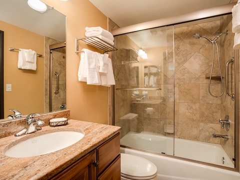 Unwind in your private spa-like bathroom featuring a deep soaking tub, walk-in shower, and plush towels ready for your arrival.
