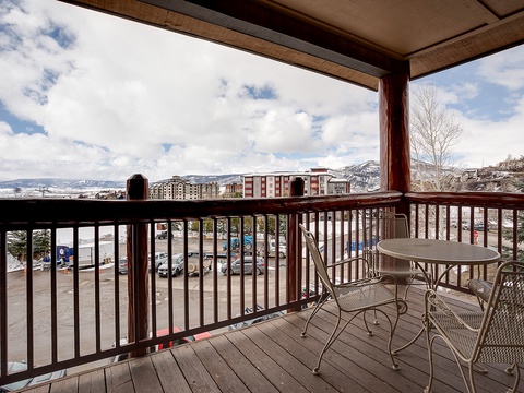 A covered balcony frames sweeping mountain and valley views, with a cozy seating area where you can unwind while taking in the fresh air and scenic surroundings.