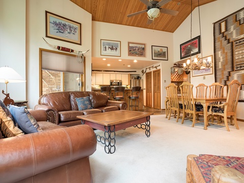 Sink into leather couches in your open-concept great room, where vaulted wood ceilings, southwestern art, and spacious dining and kitchen areas create a cozy retreat perfect for gathering.
