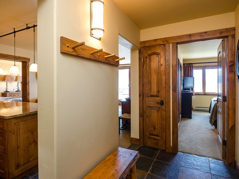 Step into your welcoming mountain retreat where rich wood tones and thoughtful design create a seamless flow between cozy living spaces, kitchen, and restful bedroom.