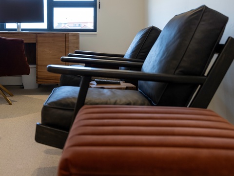 Settle into sleek leather chairs and unwind in your modern living space, where comfort meets contemporary style.
