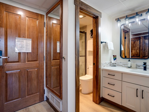 Your private bathroom features a clean vanity with ample storage, modern fixtures, and warm wood accents that invite relaxation after a day of exploring.
