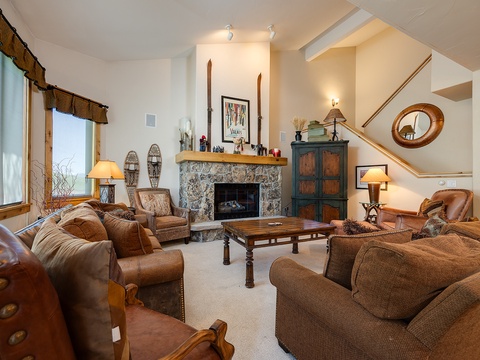 Sink into plush seating around your stone fireplace, where rustic charm meets mountain elegance. The vaulted ceilings and warm lighting create a cozy retreat after your day of adventure.
