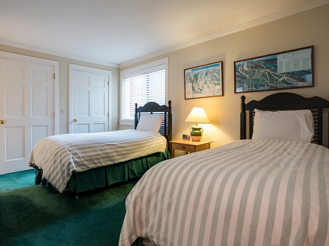 Wake up refreshed in your cozy twin-bedded room with classic mountain decor, warm lighting, and soft linens—perfect for a restful retreat together.