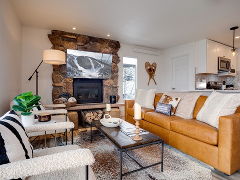 Unwind in your cozy living room featuring a stunning stone fireplace, plush leather seating, and mountain-modern décor. The open layout connects seamlessly to your fully-equipped kitchen for easy entertaining.