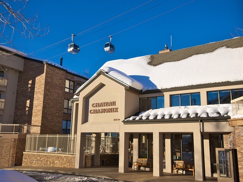 Chateau Chamonix entrance welcomes guests to a premier ski-in location beneath the iconic gondola, surrounded by mountain village charm and fresh alpine snow.