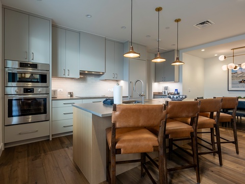 Gather around your spacious island for morning coffee or casual meals in this sleek, fully-equipped kitchen. With modern appliances and warm pendant lighting, it's designed to make you feel right at home.
