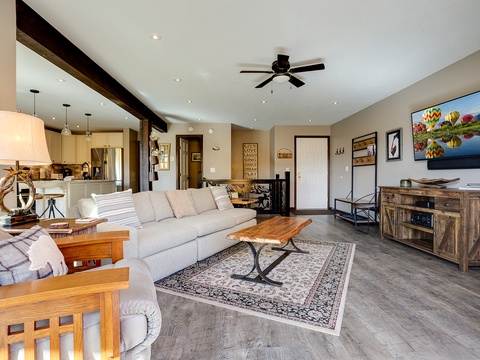 Sink into plush seating in this stylish open-concept living space, where rustic wood accents meet modern comfort—your perfect home base for relaxation and entertainment.