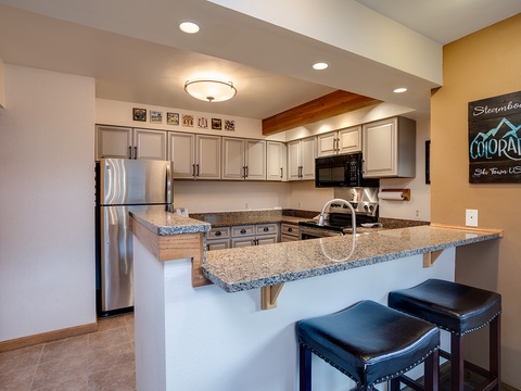 Gather around this spacious kitchen with granite countertops, full appliances, and bar seating—perfect for preparing meals together and sharing stories after a day on the slopes.