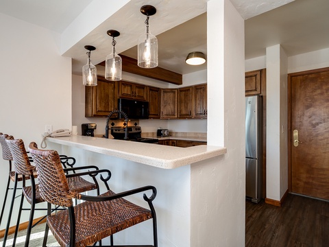 Picture yourself preparing meals in this inviting kitchen, complete with stylish pendant lighting, warm wood cabinetry, and a breakfast bar where you can sip your morning coffee.
