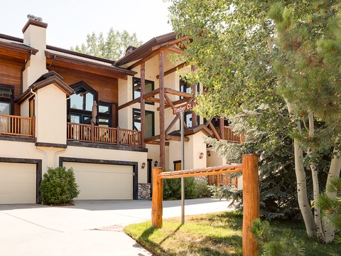 Timber Creek Estates welcomes guests with rustic alpine architecture, warm wood accents, and a peaceful mountain setting surrounded by mature trees.