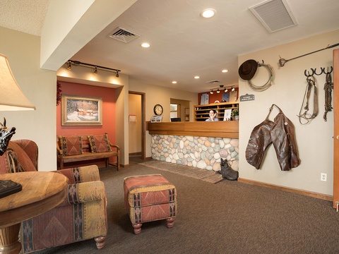 The lodge's reception area welcomes guests with warm Western charm, featuring authentic ranch décor, cozy seating, and rustic stonework that sets the tone for your mountain getaway.