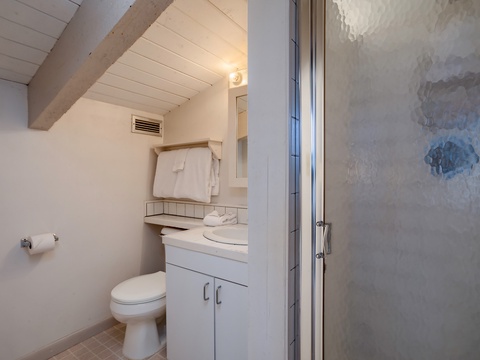 Freshen up in your bright, clean bathroom with plush towels, a spacious vanity, and a walk-in shower featuring coastal-inspired tile—designed for your comfort and relaxation.