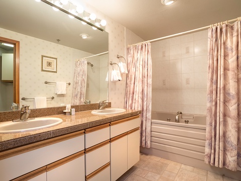 Step into your spacious bathroom featuring dual sinks, ample counter space, and a relaxing tub—perfect for unwinding after a day of adventure.