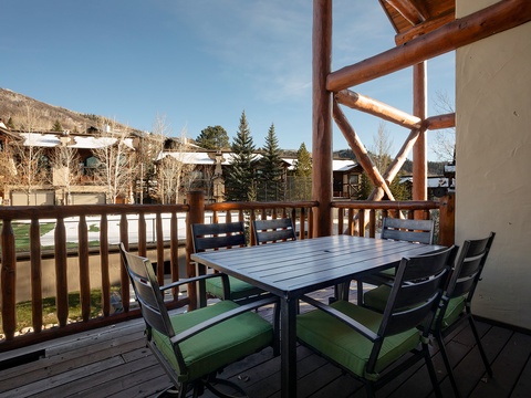 Dine outdoors under a rustic log-beam pergola overlooking the mountain neighborhood, where your morning coffee or evening meals come with crisp air and scenic views.
