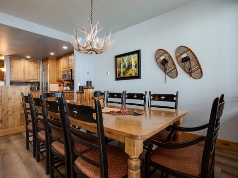 Gather around this rustic dining table for family meals and memorable evenings. The antler chandelier and charming snowshoe decor create a cozy mountain lodge feel you'll love.