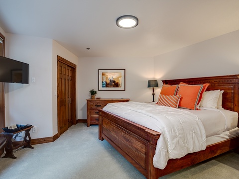 Sink into crisp white linens and plush pillows on your handsome wooden bed. Warm touches like local artwork and a reading lamp make this your perfect mountain retreat.