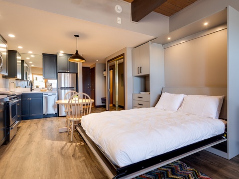 Settle into your private studio where thoughtful design meets comfort—crisp white linens await on your Murphy bed, while a fully equipped kitchen invites you to cook as you please. Warm wood tones and modern touches create a welcoming retreat.