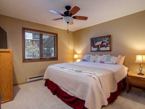 Your cozy bedroom retreat features a comfortable king bed, warm lighting, and a ceiling fan to keep you comfortable throughout your stay.