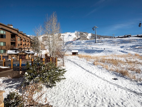 Scenic mountain resort property nestled at the base of ski slopes with convenient ski lift access and winter trail paths right outside.