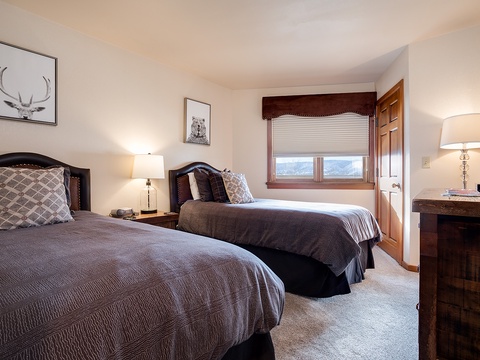 Two comfortable beds await your arrival in this cozy guest room, featuring elegant decor and mountain views to help you unwind after a day of adventure.