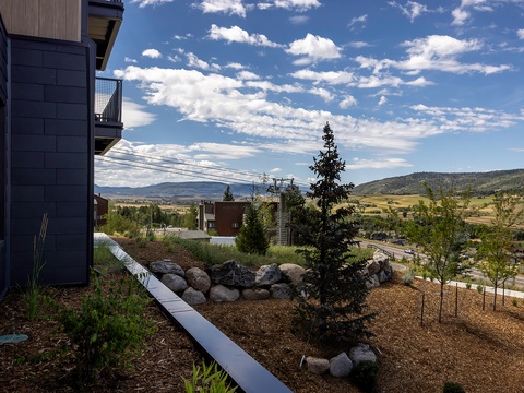 The property sits amid scenic mountain terrain with natural landscaping and expansive valley views stretching across the surrounding countryside.