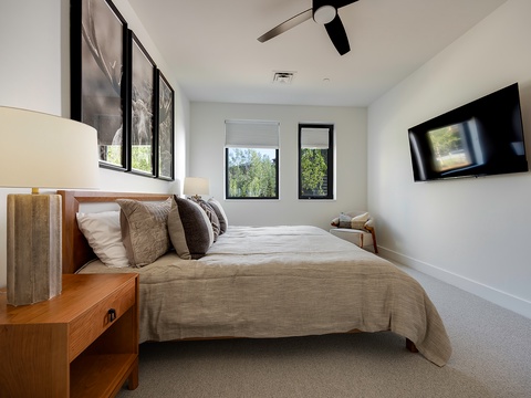 Rest easy in your peaceful bedroom sanctuary, where natural light filters through black-framed windows and modern touches create the perfect retreat after a day of exploring.