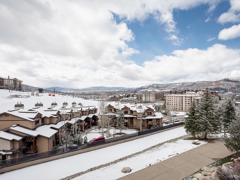 Scenic winter mountain village with snow-covered roofs and distant peaks, located near the property's surrounding area and accessible for arrival.