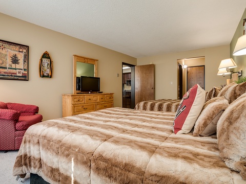 Your cozy bedroom retreat features plush bedding, warm lighting, and rustic decor that invite you to unwind after a day of mountain adventures.