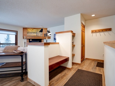 Your thoughtfully designed entryway greets you with warm wood tones, custom built-in benches for easy gear storage, and hooks to hang coats. Natural light flows through the open layout, creating a welcoming space to settle in.