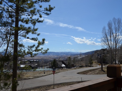 A peaceful mountain neighborhood framed by evergreens, offering stunning views of distant peaks and valleys—an idyllic setting for a quiet getaway.