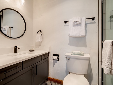 Freshen up in your private bathroom, where modern fixtures, fluffy towels, and a sleek vanity create a calming retreat after a day of adventure.