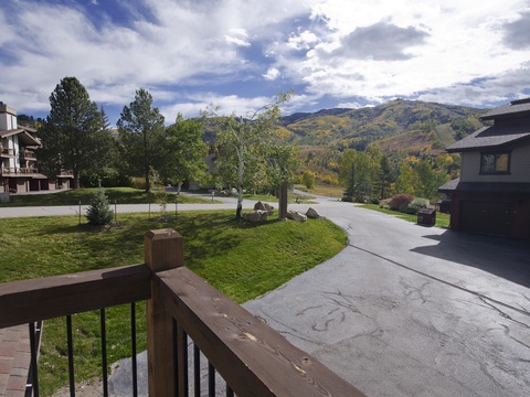 A peaceful mountain neighborhood frames your vacation retreat, with colorful hillsides and a quiet street creating a serene alpine setting.