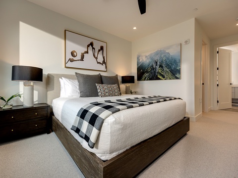 Sink into crisp white linens and soft accent pillows in your serene bedroom, where natural light spills across clean lines and thoughtful design invites your most restful sleep.